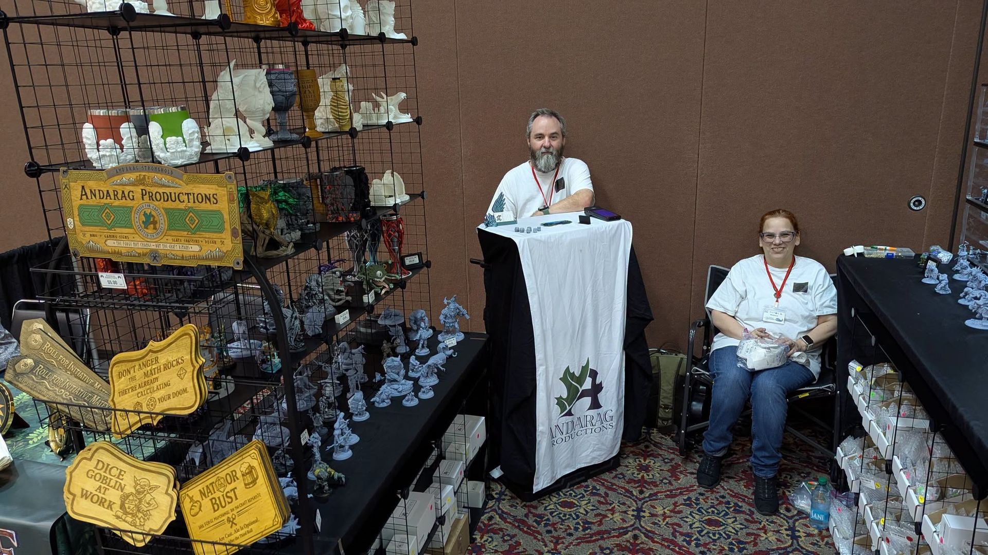 Andarag Productions booth at DieCon with a vendor standing beside a fantasy-themed display.