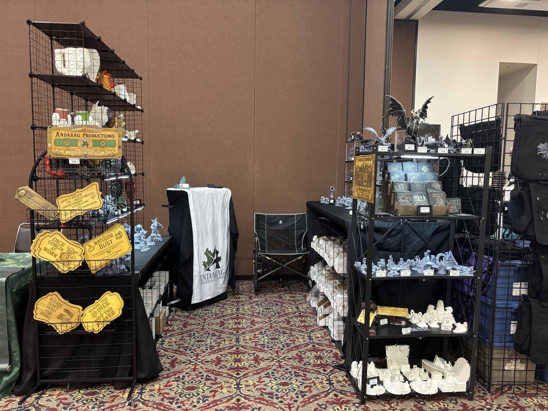 Andarag Productions booth at DieCon showcasing miniatures, dice towers, terrain, and gaming gifts.